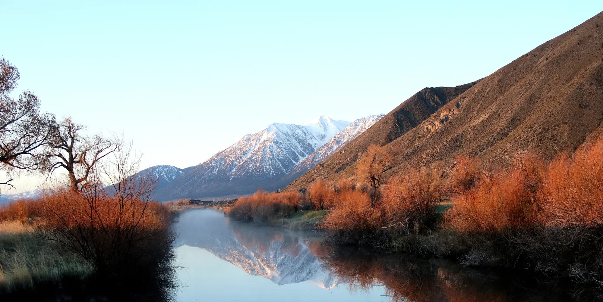 Un pico con nieve reflejado en un río tranquilo cerca de Carson City