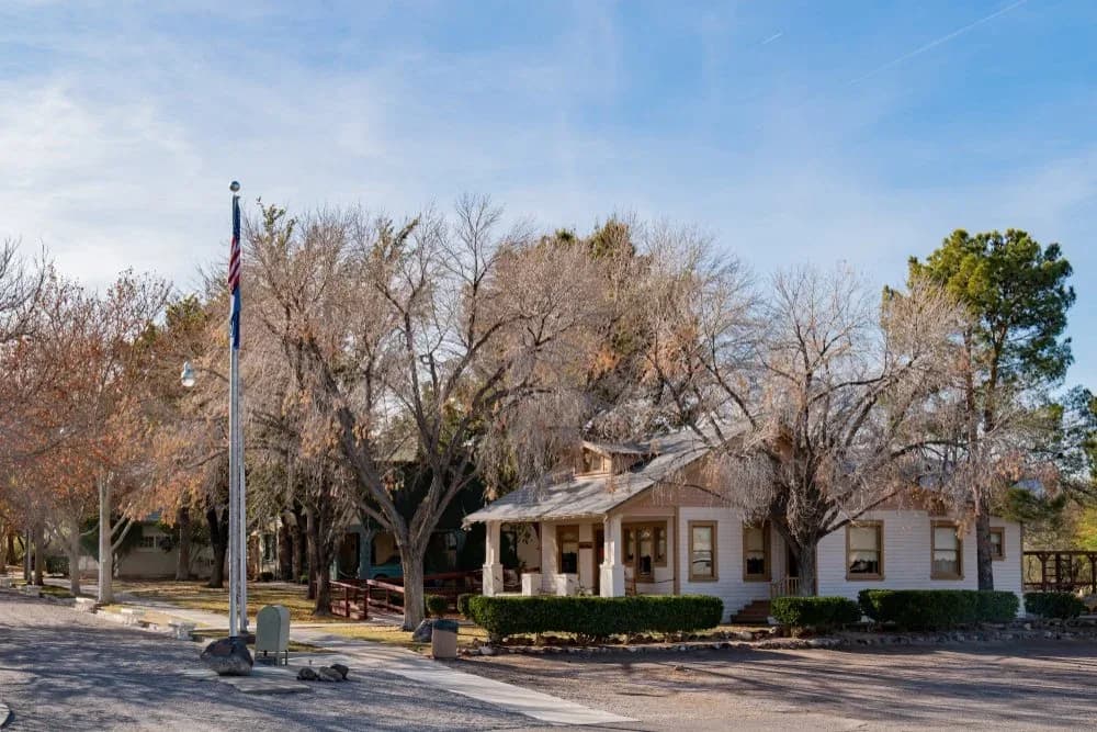 A historic ranch house under bare cottonwoods