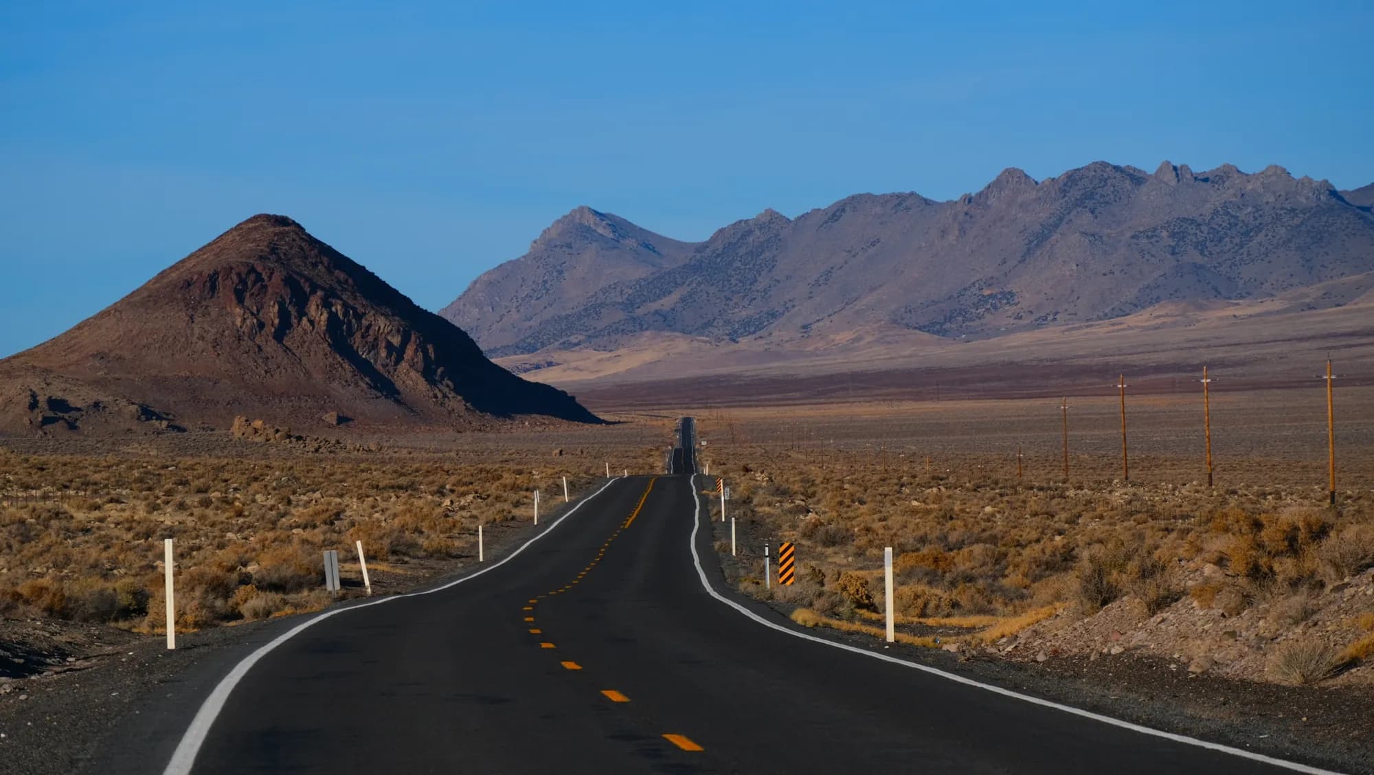 Una carretera en el desierto que lleva hacia picos escarpados