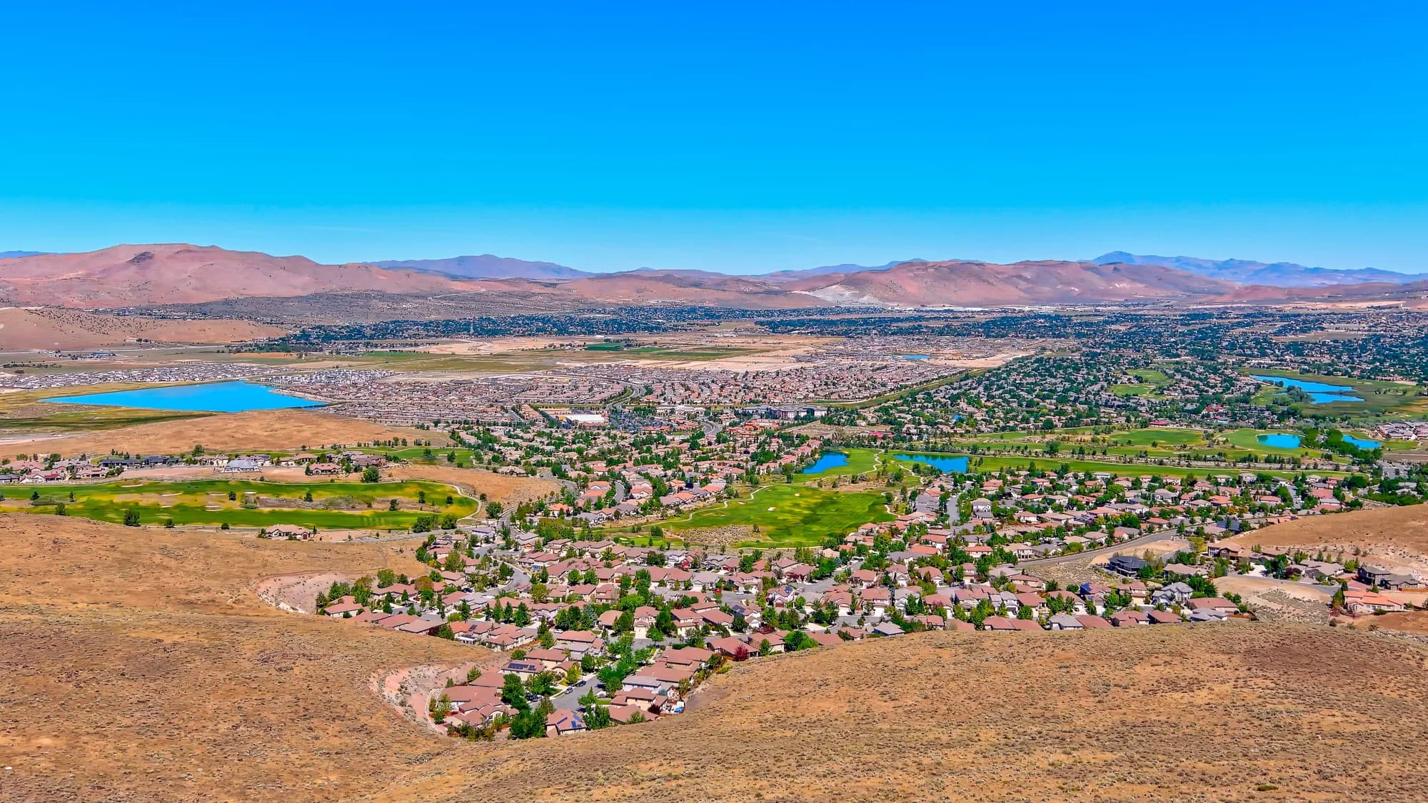 Vista aérea de casas, lagos y campos de golf en el valle